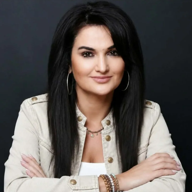 Portrait of Fatima Nery in a cream jacket against a dark background